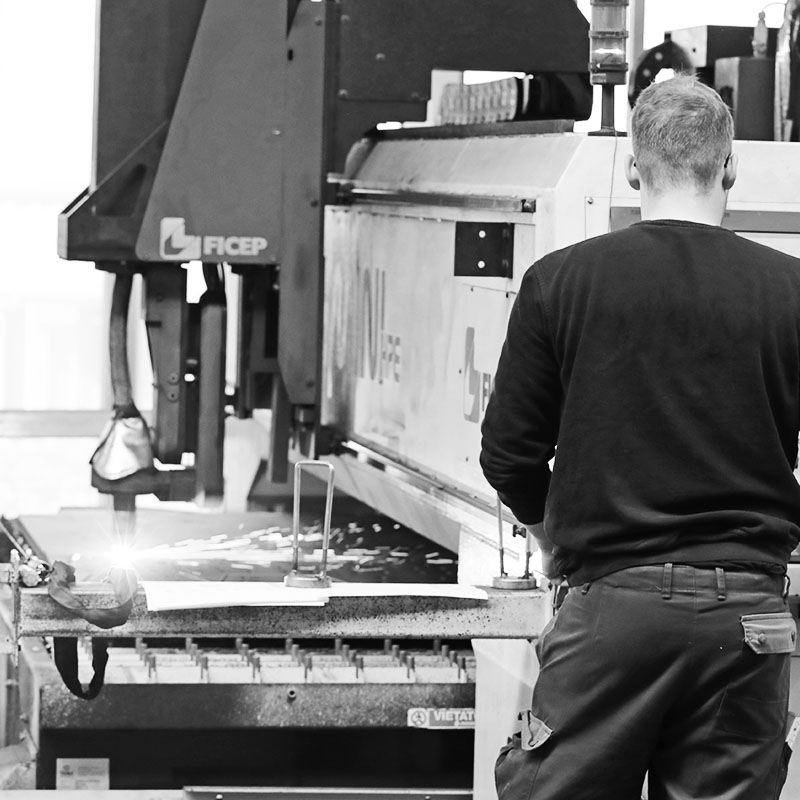 Das Foto zeigt einen Mitarbeiter von HAHNER Technik an einer Plasmaschneid-Maschine